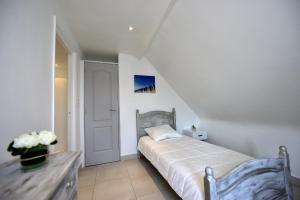 ベルク・シュル・メールにあるAppartement "Plaisir iodé" - 50m Front de Merの白いベッドルーム(ベッド1台、テーブル付)