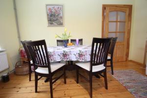 a dining room table with chairs and a floral table cloth at Ligatne Homestay in Līgatne +46 photos