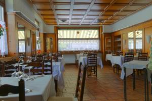 ロカルノにあるHotel Coronaのダイニングルーム(テーブル、椅子、白いテーブルクロス付)