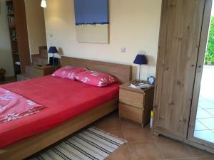 アルキッツァにあるSilia's Happy Homeのベッドルーム1室(赤い掛け布団、テーブル付)