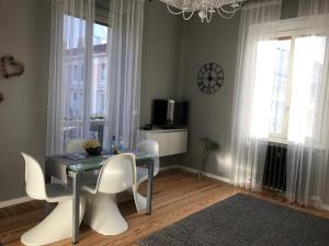 a dining room with a table and white chairs at Liberty in centro in Cuneo