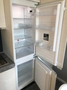 an empty refrigerator with its door open in a kitchen at Liberty in centro in Cuneo