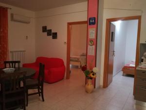 a living room with a red couch and a table at Casa Vacanze Isabella in Aliano