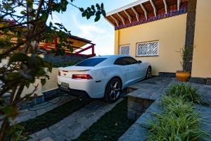 een witte auto geparkeerd buiten een huis bij Ap Casal Localização e Segurança in Campos do Jordão