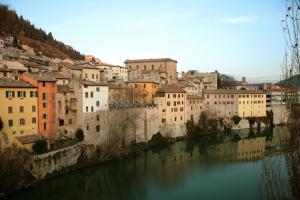 Blick auf eine Stadt mit Fluss und Gebäuden in der Unterkunft Il Cavallino in Fossombrone