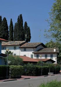 ein großes weißes Gebäude mit Bäumen im Hintergrund in der Unterkunft Corte Mantovani in Colà di Lazise