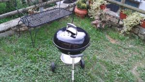 a grill sitting in the grass in a yard at Casa da 2 a 7 posti nelle Piccole Dolomiti in Recoaro Terme