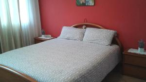 1 dormitorio con cama blanca y pared roja en Casa da 2 a 7 posti nelle Piccole Dolomiti en Recoaro Terme