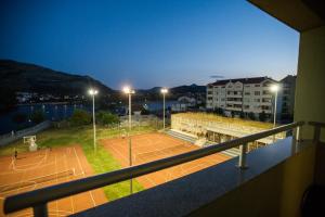 a balcony with a tennis court at night at Apartman Srna in Trebinje