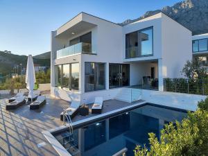 a large white house with a swimming pool at Villa Selina - Nera in Makarska