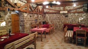 a restaurant with red tables and chairs and brick walls at Apartment Mond in Virpazar