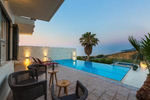 a villa with a swimming pool and a patio at Sea View Villas in Episkopí- Rethimno