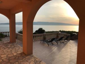 un portico con sedie e vista sull'acqua di Apartments Mediterano a Senj