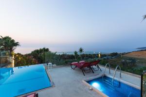a house with a swimming pool and a table at Sea View Villas in Episkopí- Rethimno