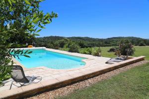 a swimming pool with two chairs in a yard at The Garden Room in Villamblard