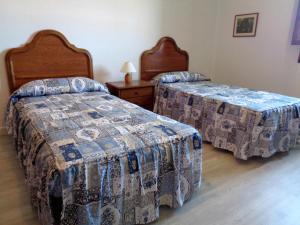 Un dormitorio con dos camas y una mesa con lámpara. en AT Villa Manola, en Colombres