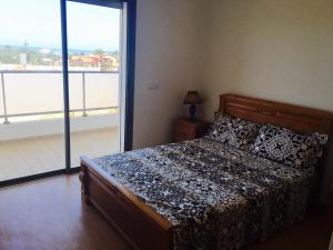 ein Schlafzimmer mit einem Bett und einem großen Fenster in der Unterkunft Paradise beach in Mohammedia