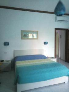 sypialnia z łóżkiem z niebieską narzutą w obiekcie Garden Bijou with Sea View w mieście Vietri sul Mare