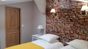 ユゼスにあるGite des Alexandrinsのレンガの壁、ベッド2台が備わるベッドルーム1室が備わります。
