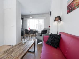 デン・ブルグにあるCatharina Texelのリビングルーム(赤いソファ、テーブル付)