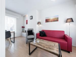 sala de estar con sofá rojo y mesa en Catharina Texel, en Den Burg