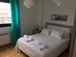 sypialnia z łóżkiem i dwoma ręcznikami na nim w obiekcie Alojamiento La Rosaleda w mieście Ponferrada