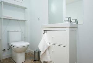 a white bathroom with a toilet and a sink at Quintero Suites in San Bartolomé +22 photos
