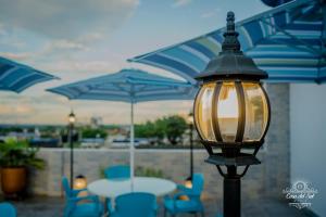 Casa del Sol في فيلافيسينسيو: اضاءة الشارع مع الكراسي الزرقاء والطاولات والمظلات