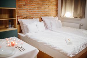 2 camas con almohadas blancas y mesa con mesa en Comfortable Studio near Słodowiec Metro Lula Apartments, en Varsovia