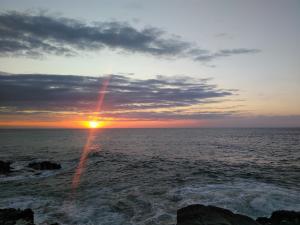 um pôr-do-sol sobre o oceano com o pôr-do-sol em Uberkei em Coffee Bay