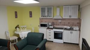 a kitchen with white cabinets and a table with chairs at Apartment Aqua Royal in Arandelovac