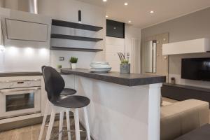 uma cozinha com um balcão e uma cadeira preta em C-Apartment Civico88 em Pádua