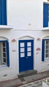 a blue door on a white building with blue windows at Marouso Villa Paros in Márpissa