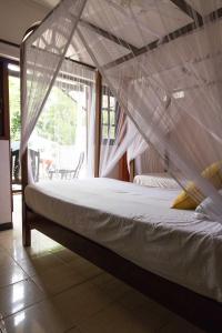 un letto con una rete in una stanza di Villa Taprobane a Negombo