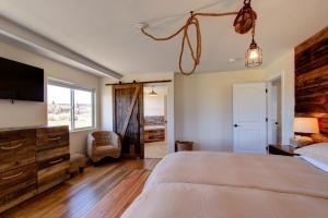 a bedroom with a large bed and a flat screen tv at Sevier River Retreat in Hatch