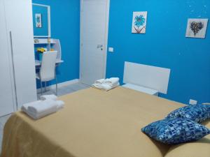 a blue room with a bed with towels on it at Etna En Vie in Zafferana Etnea