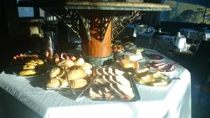 una mesa con varios platos de comida. en Pousada das Palmeiras en Camanducaia