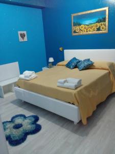 a bedroom with a large bed with a blue wall at Etna En Vie in Zafferana Etnea