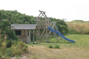 a playground with a slide in a field at Hotel Lakolk in Rømø Kirkeby