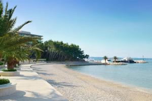 una spiaggia con palme accanto all'acqua di Villa Kozina a Podstrana