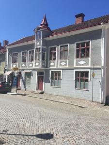 a large white building on a cobblestone street at Brahe 65 in Gränna +7 photos