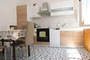 eine Küche mit einem Tisch und einem weißen Kühlschrank in der Unterkunft Holiday House Palma in Dobrinj + 36 Fotos