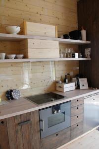 a kitchen with wooden cabinets and a stove top oven at Lindeborgs Eco Retreat in Vrena