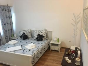 a small bedroom with a bed and a table at Casa De Sub Piatra in Baia de Fier