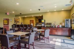 een restaurant met tafels en stoelen en een bar bij Cobblestone Hotel & Suites - Orrville in Orrville