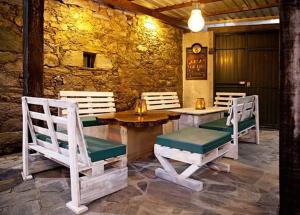 patio z białymi krzesłami, stołem i ławkami w obiekcie Casa Don Din w mieście Cruces