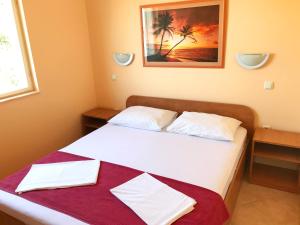 una camera con un letto con due cuscini bianchi di Antonio Apartments a Trogir