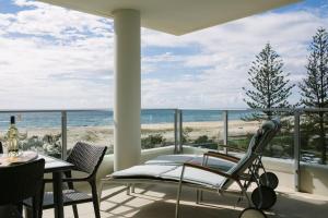 balcón con mesa, sillas y vistas al océano en Pure Kirra, en Gold Coast