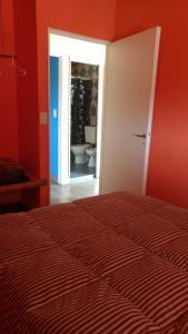 a bedroom with a bed and a bathroom with a toilet at La Nave del Olvido- Cabaña Potrerillos in Potrerillos +52 photos