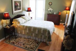 a bedroom with a bed and two lamps and a rug at Forest Hill Bed and Breakfast in Kitchener